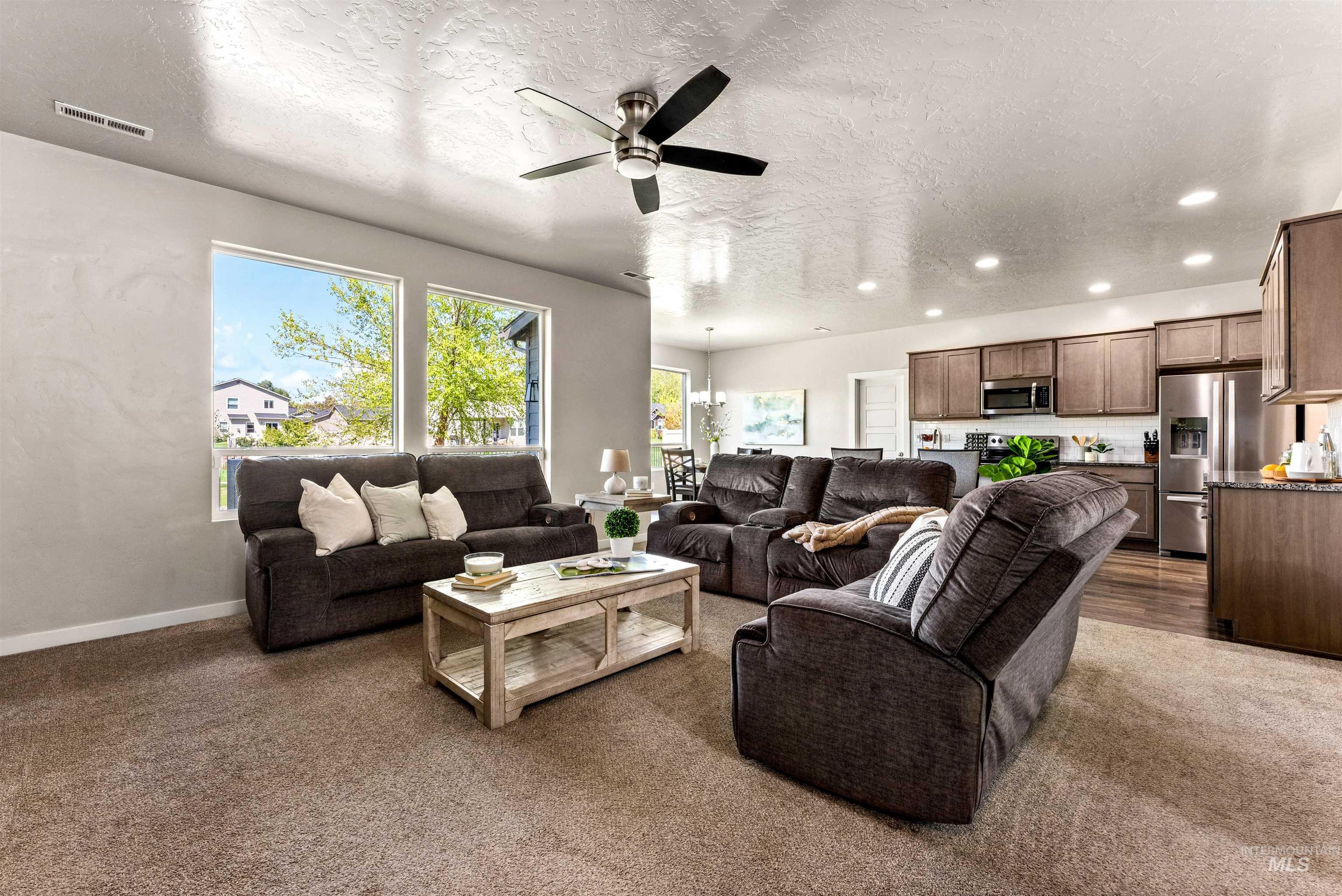 10890 West Sharpthorn Street Boise, ID 83709 - Photo 7 of 50 Open-concept living space featuring a ceiling fan, recessed lighting, and large windows