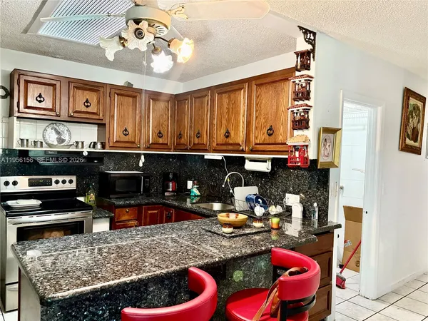 a kitchen filled with stainless steel appliances granite countertop a sink and a refrigerator