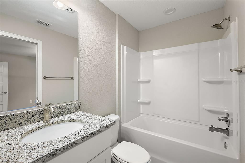 13740 Southwest 89th Street Dunnellon, FL 34432 - Photo 16 of 25 a bathroom with a granite countertop sink toilet tub and shower