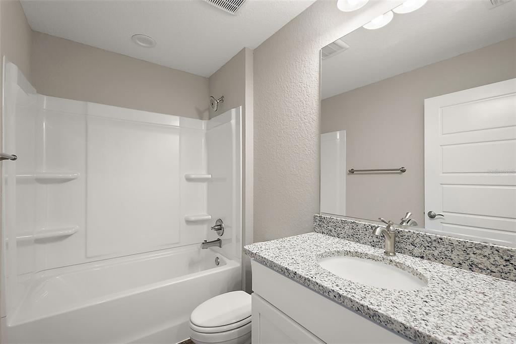 13740 Southwest 89th Street Dunnellon, FL 34432 - Photo 18 of 25 a bathroom with a granite countertop bathtub shower sink vanity mirror and toilet