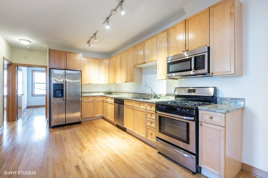 Undisclosed Address Chicago, IL 60657 - Photo 8 of 13 a kitchen with stainless steel appliances granite countertop a stove a refrigerator and a microwave