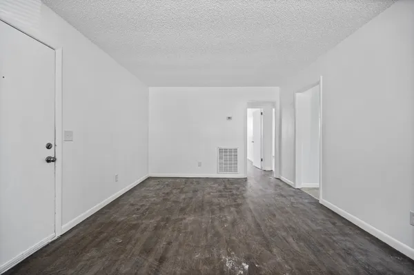 a view of an empty room with wooden floor
