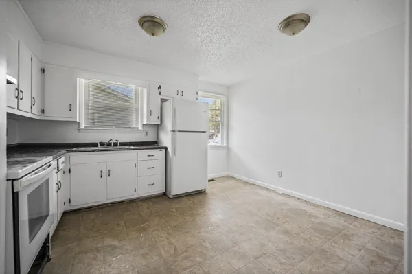 a kitchen with granite countertop cabinets and white appliances