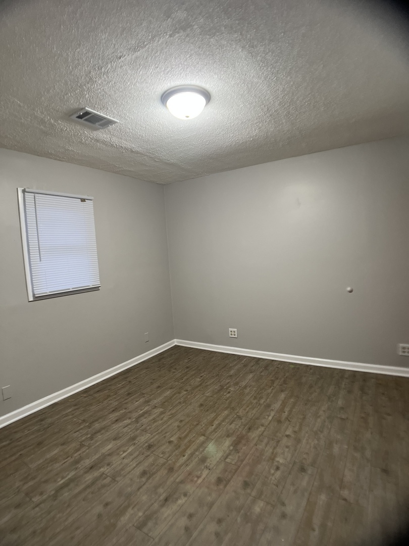 16237 Trumbull Avenue Markham, IL 60428 - Photo 15 of 18 an empty room with wooden floor and windows