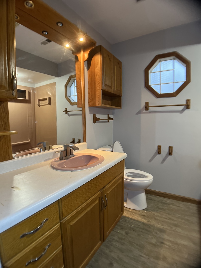16237 Trumbull Avenue Markham, IL 60428 - Photo 16 of 18 a bathroom with a toilet sink and mirror
