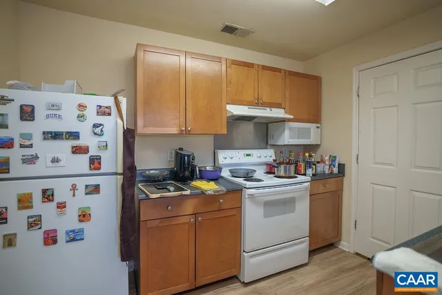 a kitchen with stainless steel appliances a sink a stove a refrigerator and cabinets