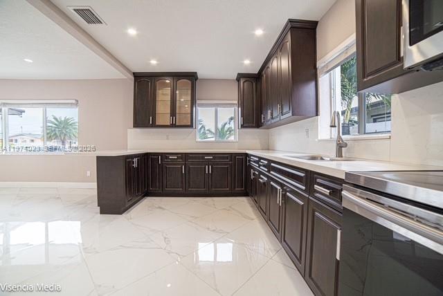 6271 Northwest 110th Street Hialeah, FL 33012 - Photo 3 of 53 a large kitchen with a large counter top a sink stainless steel appliances and cabinets