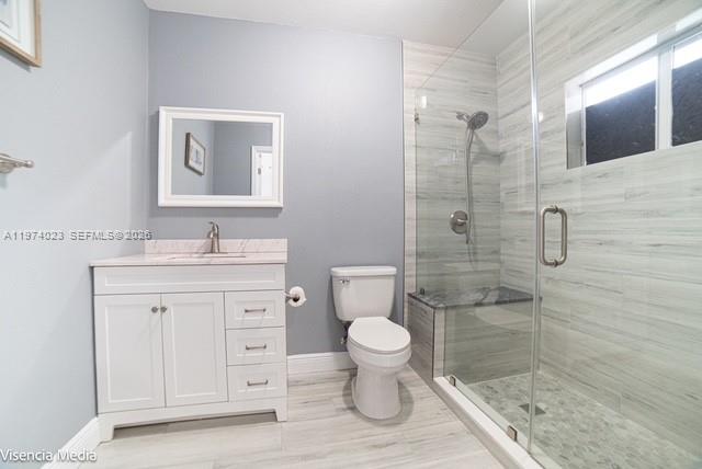 6271 Northwest 110th Street Hialeah, FL 33012 - Photo 40 of 53 a bathroom with a granite countertop toilet a sink and a mirror