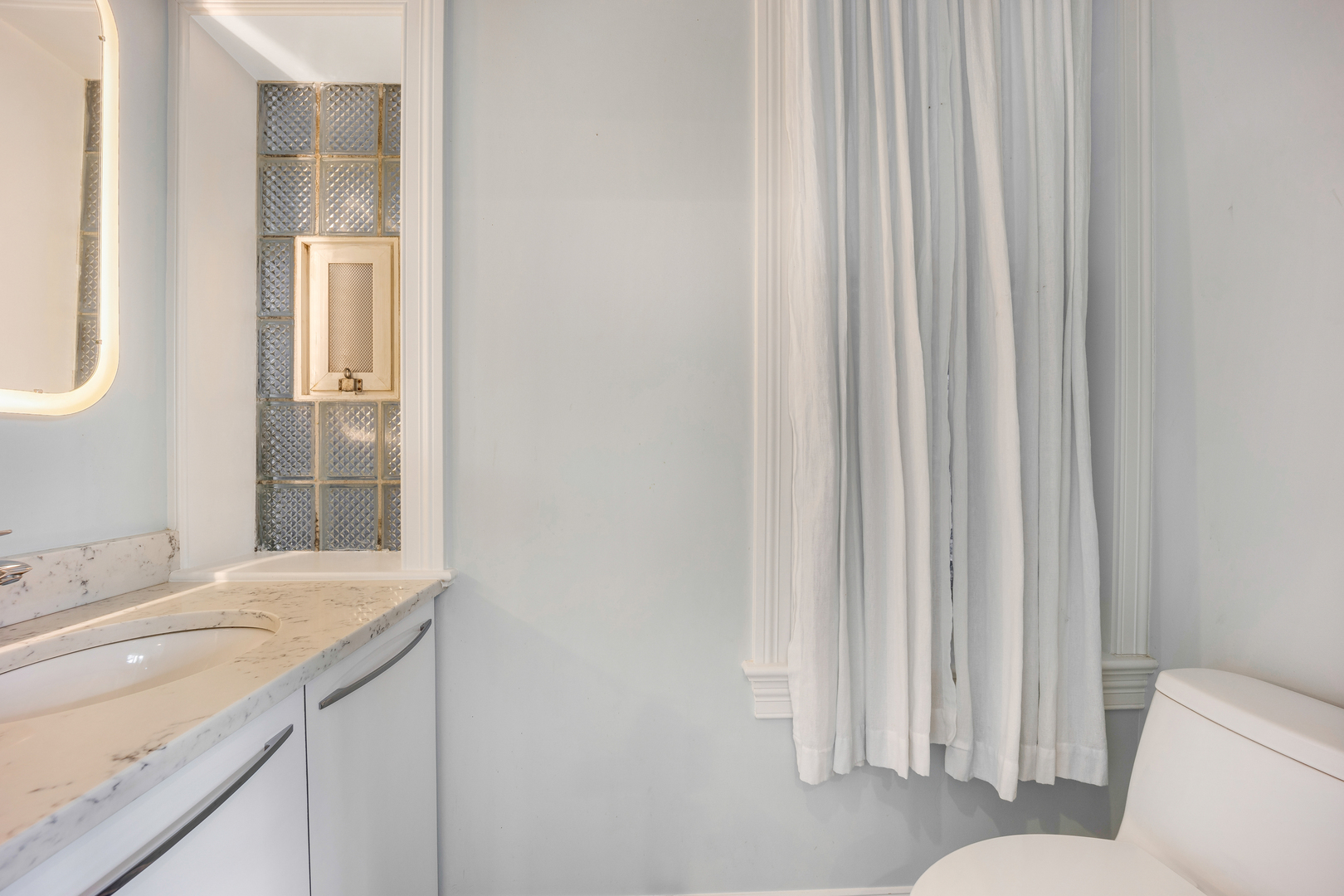 1317 West 18th Place, Unit 1F Chicago, IL 60608 - Photo 15 of 26 a bathroom with a granite countertop sink and a mirror
