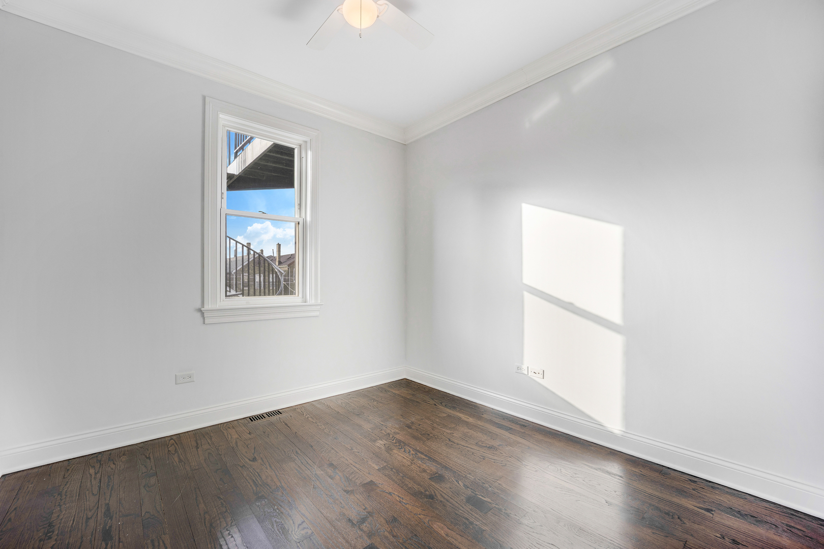 1317 West 18th Place, Unit 1F Chicago, IL 60608 - Photo 9 of 26 an empty room with wooden floor and windows