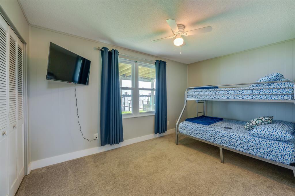 1633 Riverside Drive Daytona Beach, FL 32117 - Photo 22 of 26 a bedroom with a bed window and a flat screen tv