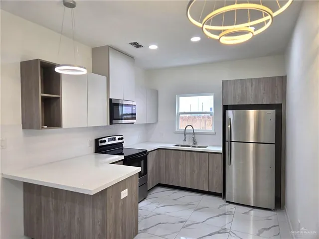 a kitchen with stainless steel appliances a refrigerator sink and microwave