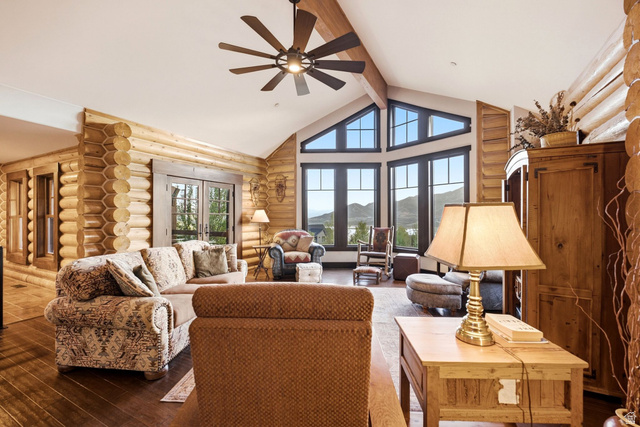 12465 Bone Road Kamas, UT 84036 - Photo 13 of 63 Vaulted ceiling featuring exposed beams, log wall construction, dark wood-finish flooring, and large picture windows