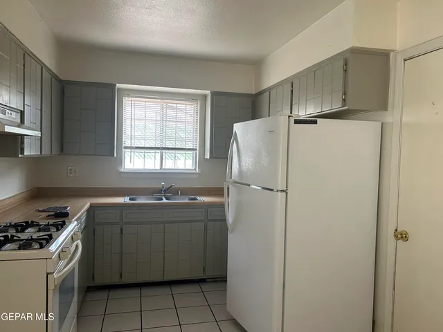 a kitchen with stainless steel appliances a refrigerator sink and stove