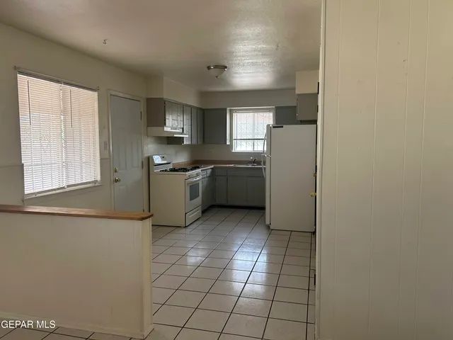a kitchen with a sink a stove top oven and cabinets