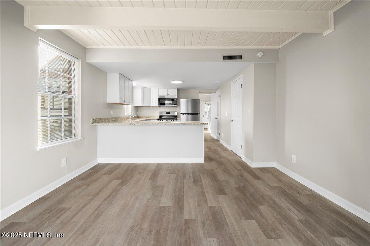 4358 Timuquana Road, Unit 208 Jacksonville, FL 32210 - Photo 11 of 28 a view of a kitchen with a sink wooden floor and cabinets