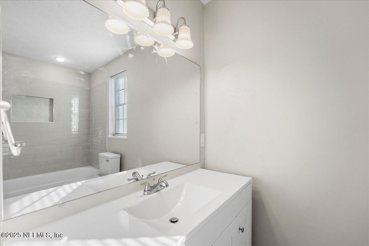 4358 Timuquana Road, Unit 208 Jacksonville, FL 32210 - Photo 17 of 28 a bathroom with a sink a vanity and a mirror
