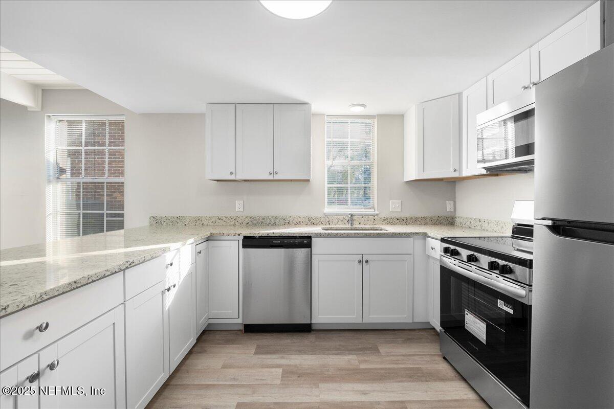 4358 Timuquana Road, Unit 208 Jacksonville, FL 32210 - Photo 10 of 28 a kitchen with granite countertop cabinets stainless steel appliances a sink and a window