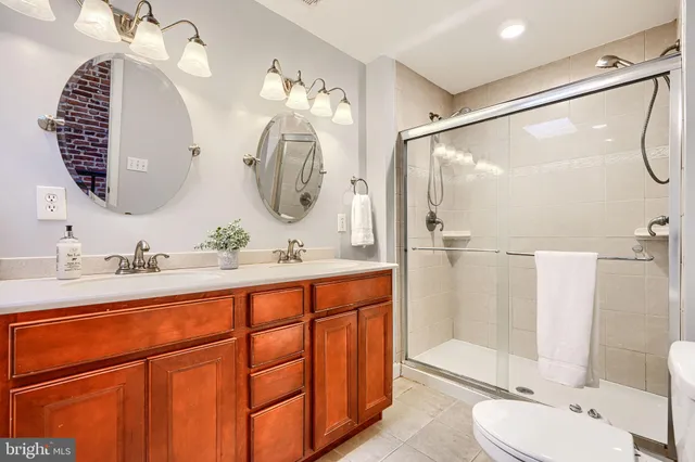 a bathroom with a double vanity sink mirror and toilet