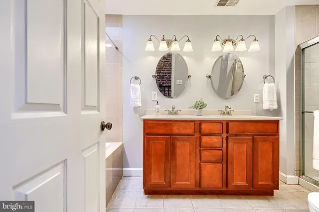 a bathroom with a double vanity sink and a mirror