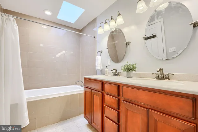 a bathroom with a granite countertop sink mirror and a bathtub