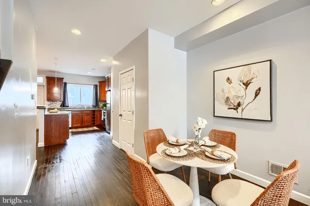 a view of a dining room with furniture a kitchen and wooden floor