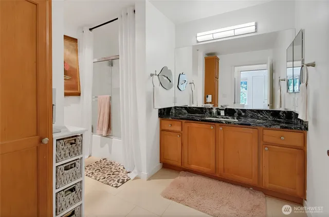a bathroom with a granite countertop sink and a mirror