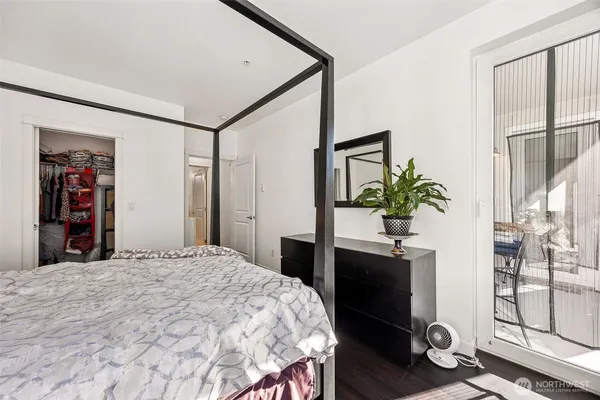 a bedroom with a large bed and a potted plant