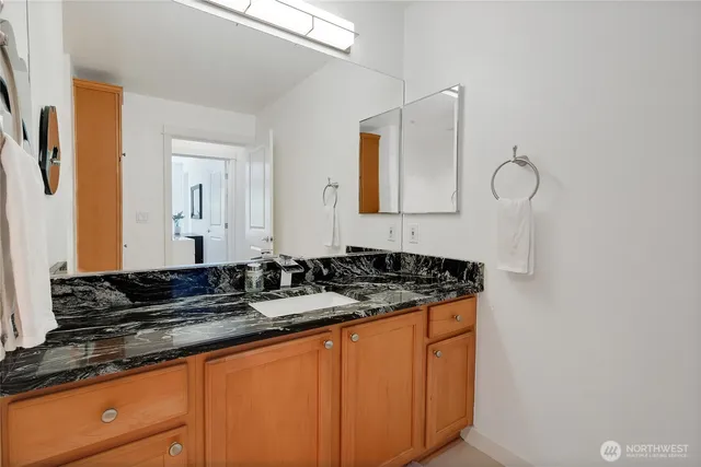 a bathroom with a granite countertop sink and a mirror