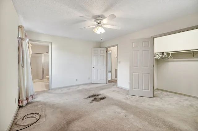 a view of a livingroom with a ceiling fan & window