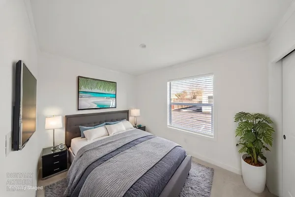 a bedroom with a bed and a potted plant