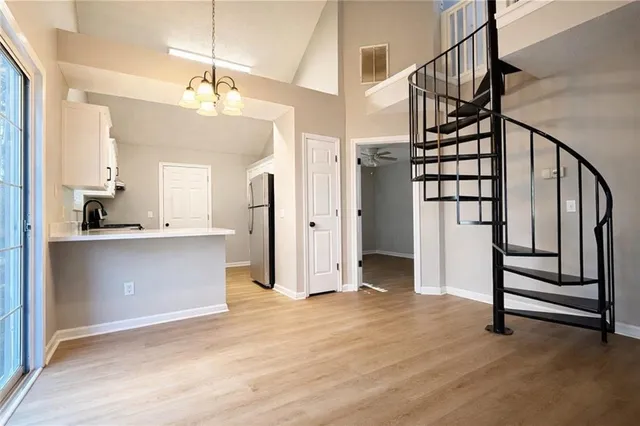 a view of a kitchen with wooden floor and electronic appliances