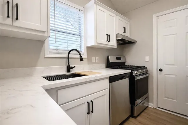 a kitchen with stainless steel appliances granite countertop a sink and a stove