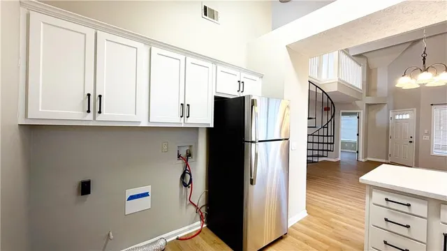 a kitchen with stainless steel appliances a refrigerator and a cabinets