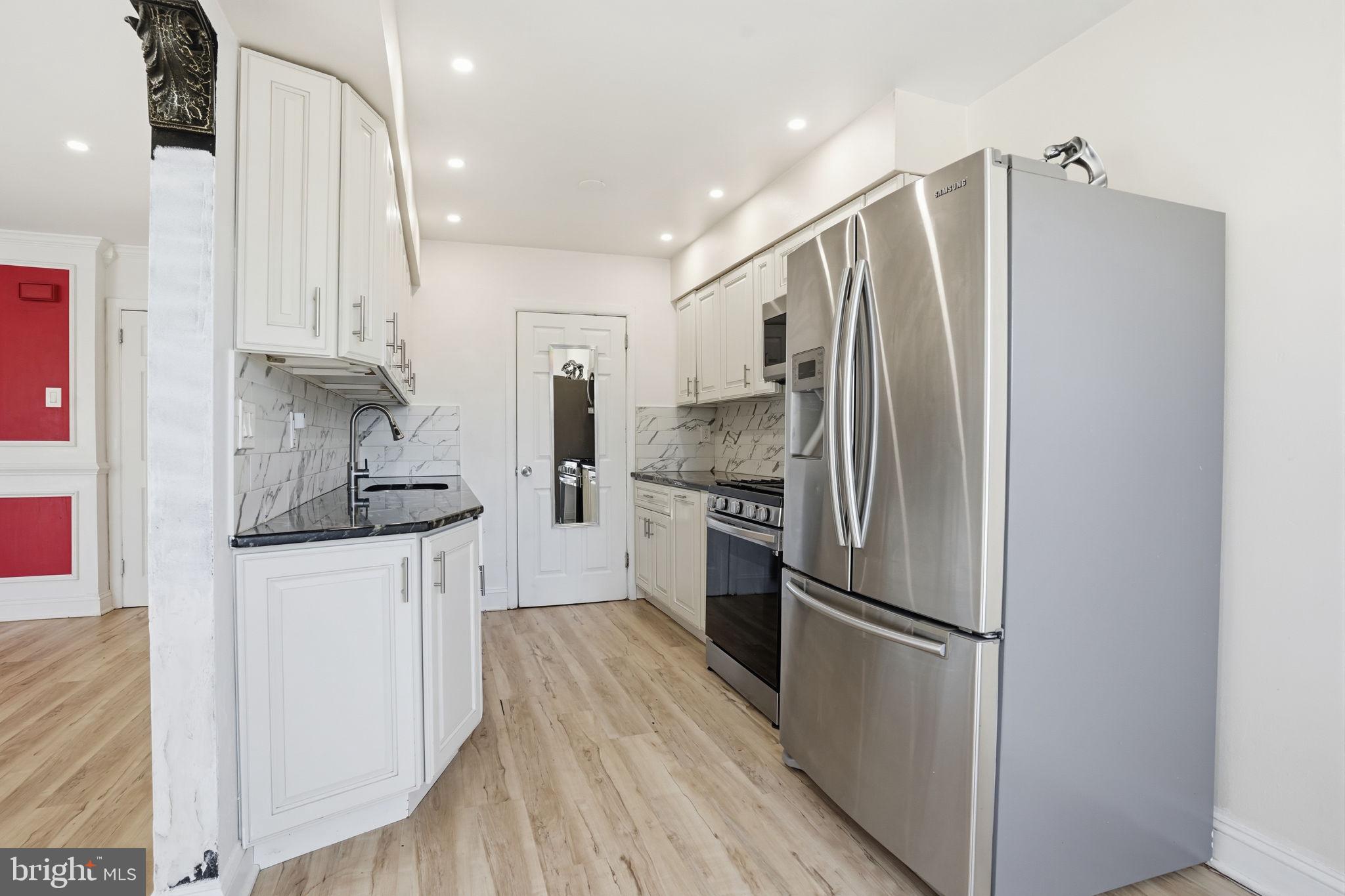 12135 Academy Road, Unit 42 Philadelphia, PA 19154 - Photo 4 of 18 a kitchen with stainless steel appliances a refrigerator sink and stove