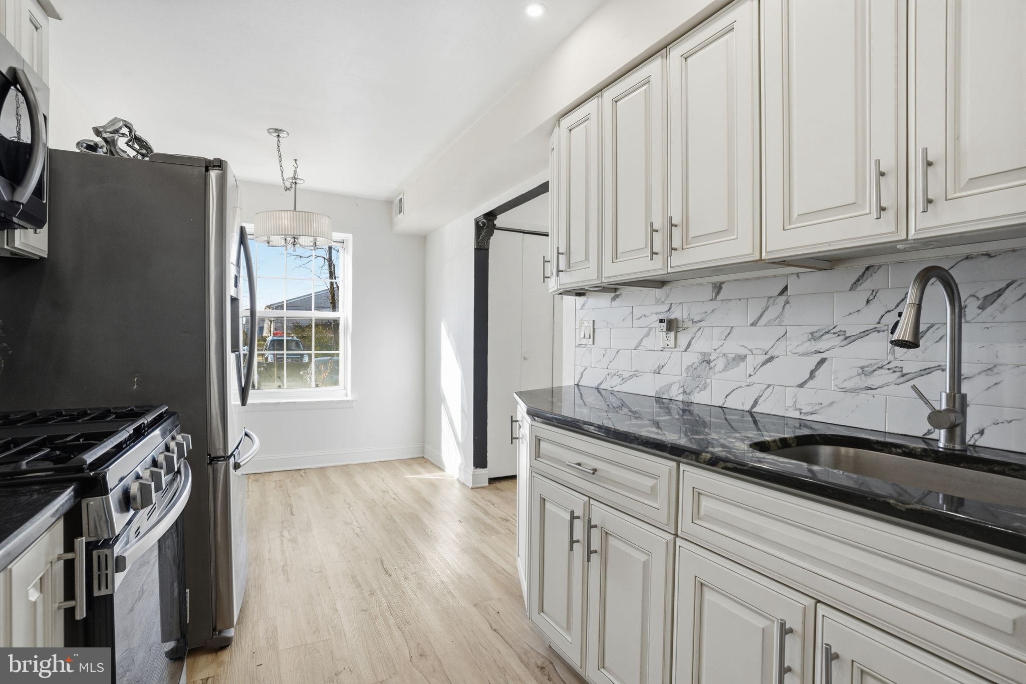 12135 Academy Road, Unit 42 Philadelphia, PA 19154 - Photo 8 of 18 a kitchen with granite countertop a sink a stove and refrigerator
