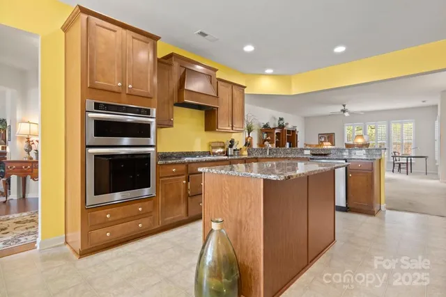 a kitchen with stainless steel appliances granite countertop a stove a sink and a refrigerator