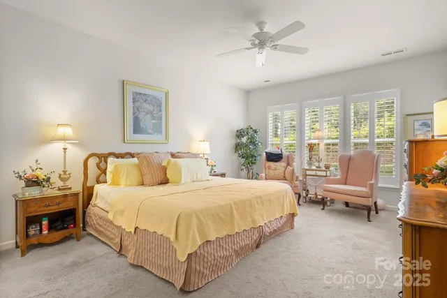 a bedroom with a bed and large windows