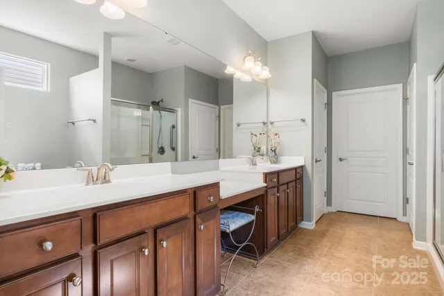 a bathroom with a sink double vanity granite tub shower and a mirror