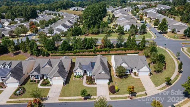 an aerial view of residential houses with outdoor space and swimming pool