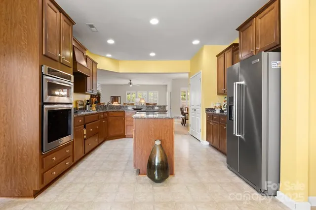 a kitchen with stainless steel appliances granite countertop a refrigerator a oven a sink and a island