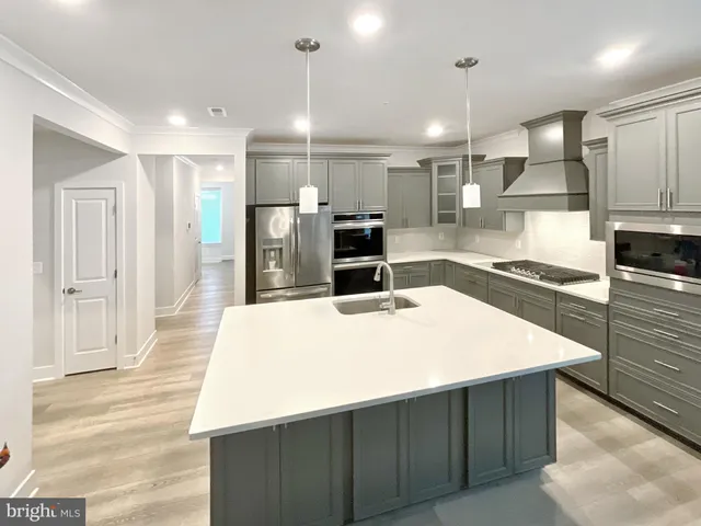 a large kitchen with kitchen island a sink stainless steel appliances and cabinets