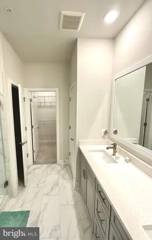 a bathroom with a granite countertop sink a mirror and a shower