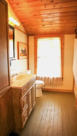 a bathroom with a sink a toilet and a window