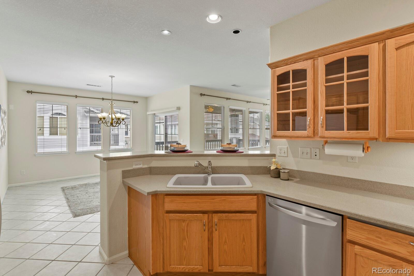 152 Whitehaven Circle Highlands Ranch, CO 80129 - Photo 13 of 25 a kitchen with stainless steel appliances granite countertop a sink and dishwasher with wooden cabinets