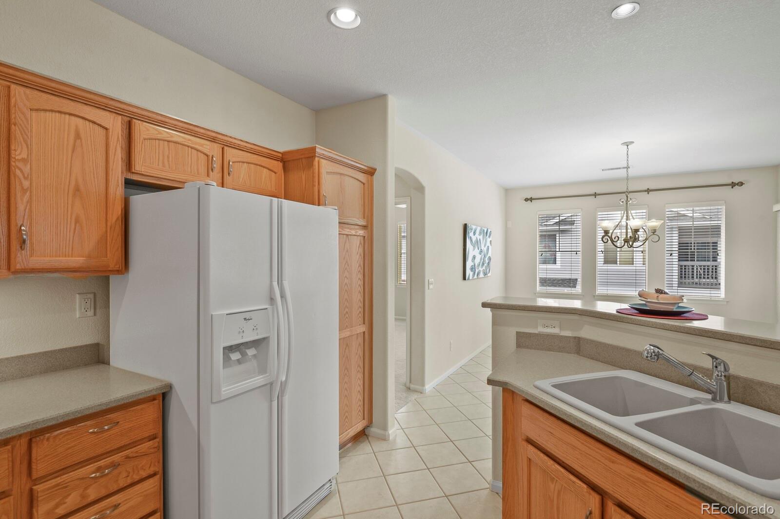152 Whitehaven Circle Highlands Ranch, CO 80129 - Photo 14 of 25 a kitchen with granite countertop a refrigerator and a sink