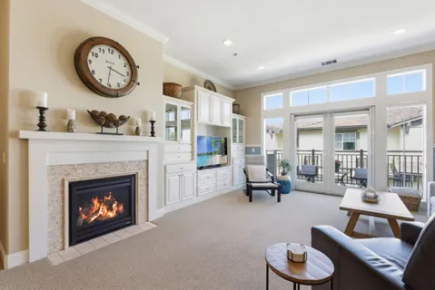 a living room with furniture a fireplace and a large window