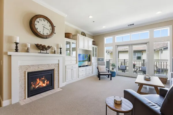 a living room with furniture a fireplace and a large window