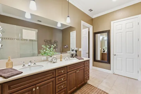 a spacious bathroom with a granite countertop double vanity sink and a mirror