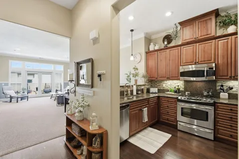 a kitchen with stainless steel appliances granite countertop a stove top oven a sink dishwasher and cabinets with wooden floor